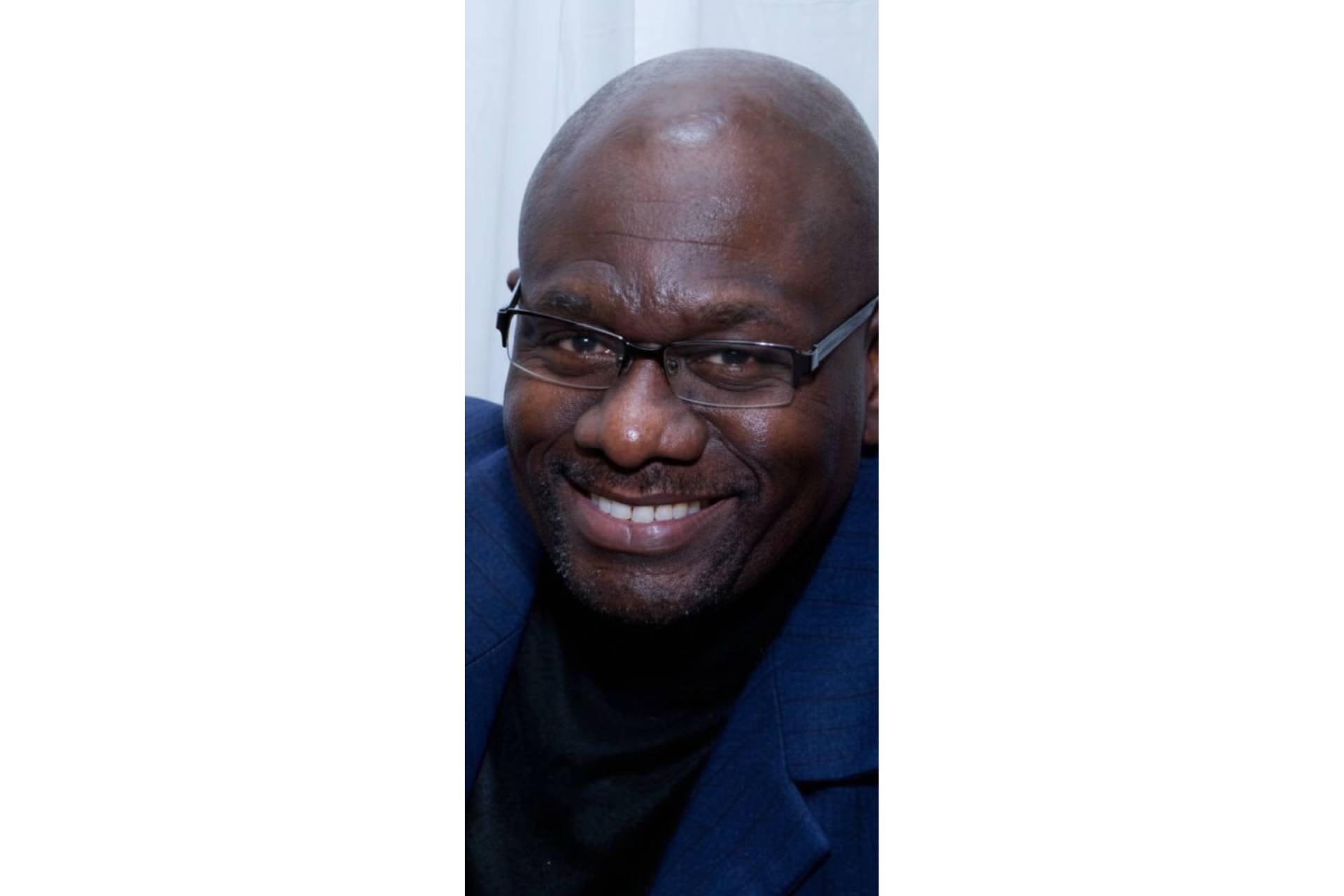 Lonnie Chambers, Restorative Justice Coordinator at Tarkington School of Excellence, smiling in a school hallway.