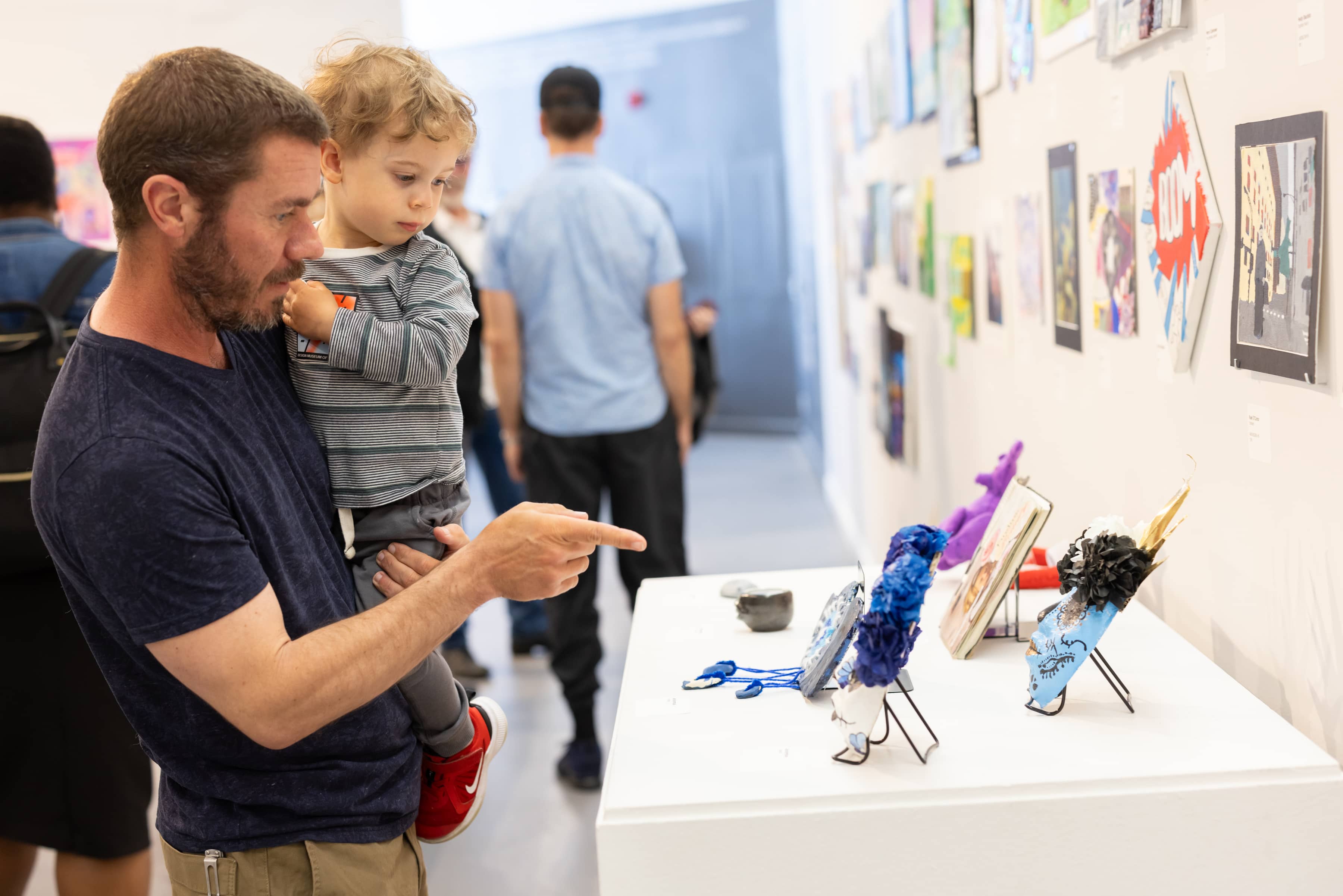 father showing child artwork